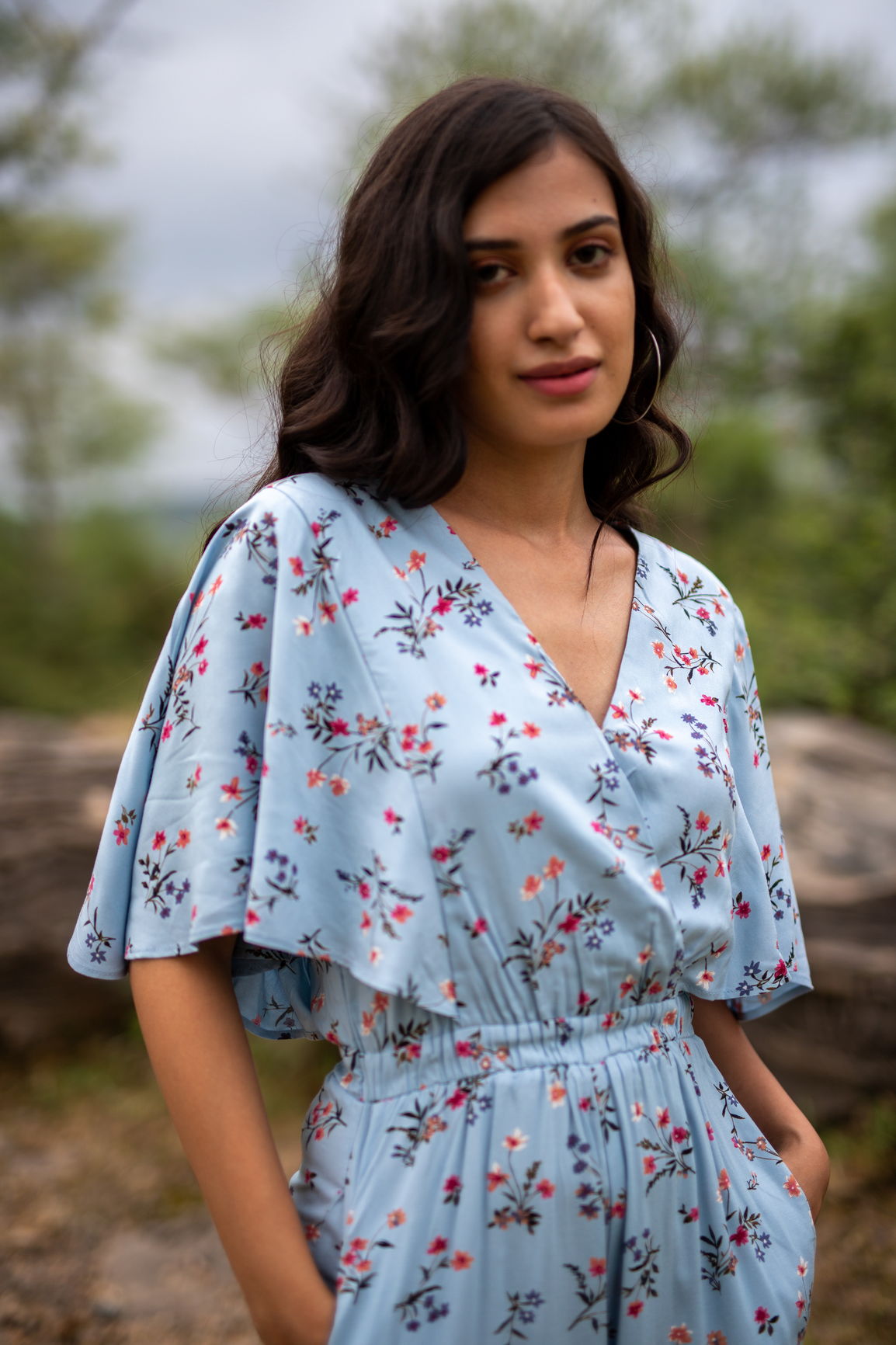 Sky blue floral jumpsuit with flowing sleeves and elegant design.