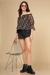 Multi Floral Top paired with black denim shorts and boots.
