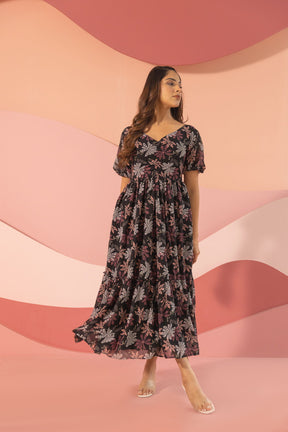 Black floral maxi dress displayed against a colorful backdrop.