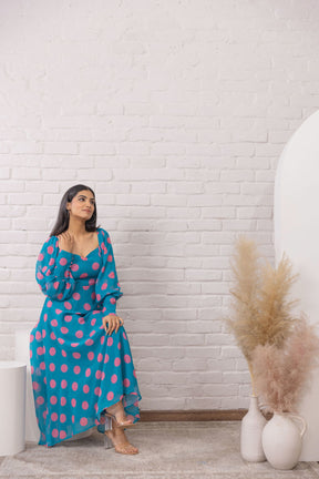 Woman wearing a blue polka dot maxi dress in a stylish setting.