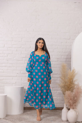 Blue polka dot maxi dress model in stylish setting.