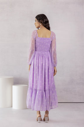 Elegant lilac smocked maxi dress with puff sleeves and floral design.