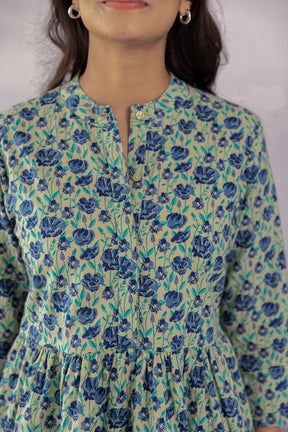 Green cotton top with blue floral print, perfect for summer style.