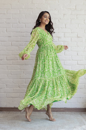 Green and yellow floral maxi dress with flowing sleeves and tiered hem.
