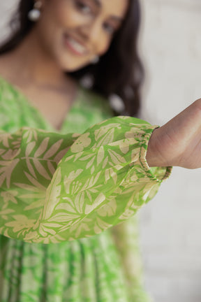 Green and yellow floral maxi dress with elegant sleeve details.