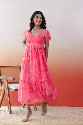 Stylish woman in pink chiffon maxi dress with layered skirt.