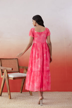 Back view of a model wearing a pink chiffon maxi dress.
