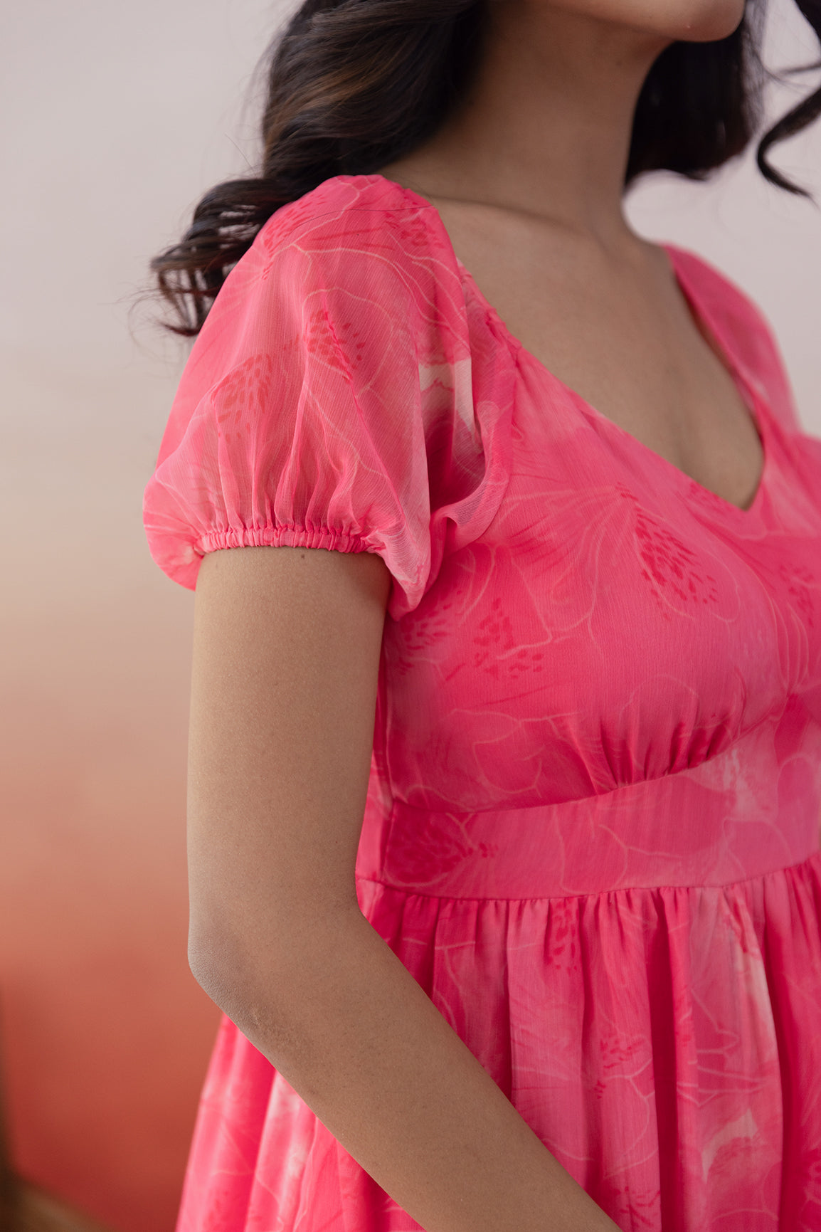 Elegant pink chiffon maxi dress with puff sleeves.