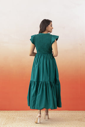 Emerald green cotton maxi dress with ruffled sleeves and tiered skirt.