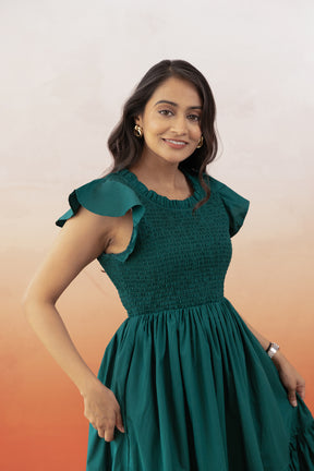 Emerald green cotton maxi dress with ruffled sleeves and fitted bodice.