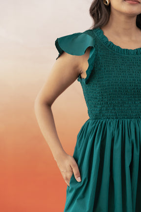Emerald green cotton maxi dress with ruffled sleeves and pleated skirt.