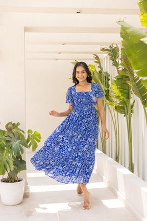 Electric blue tropical maxi dress in a stylish summer setting.