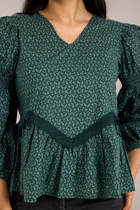 Emerald green cotton top with floral print and ruffled design.