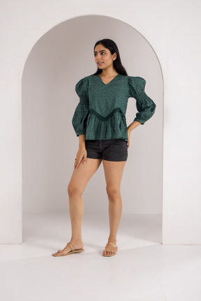 Emerald green cotton top with puff sleeves, styled with shorts.