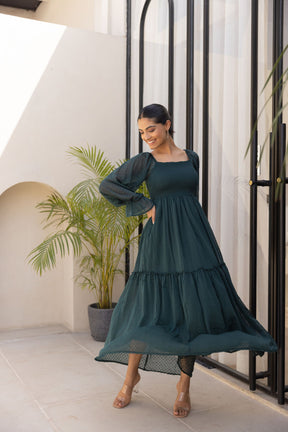 Emerald green chiffon maxi dress with flowing skirt and sheer sleeves.