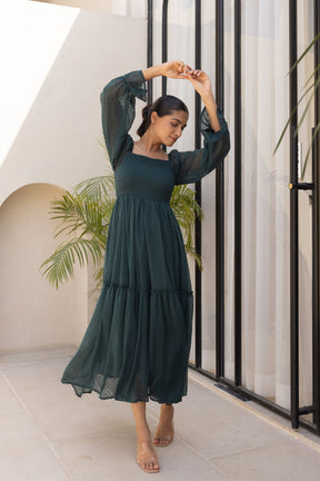 Emerald green chiffon maxi dress with puff sleeves and tiered skirt.