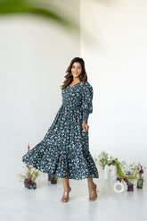 Emerald green floral smocked maxi dress on model, stylish and elegant.