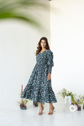 Emerald green floral smocked maxi dress on model in stylish setting.