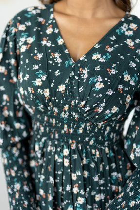 Emerald green floral smocked maxi dress with elegant detailing.