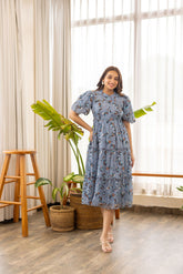 Floral nursing maxi dress worn by model indoors with plants.