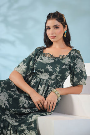 Elegant woman in green floral dress, showcasing nursing maxi style.