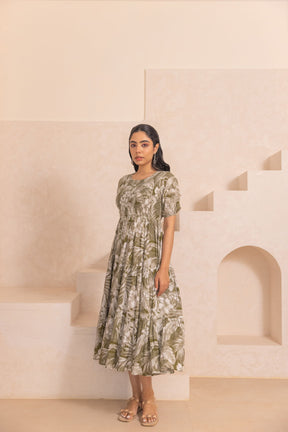 Green tropical smocked cotton maxi dress on model in stylish setting.