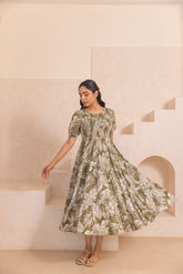 Green tropical smocked cotton maxi dress in a stylish setting.