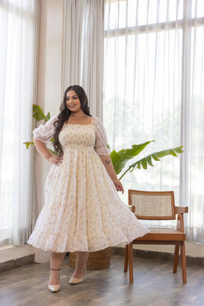Elegant woman in pastel floral dress, showcasing MINIMAL MAXI - POLAGO PLUS.