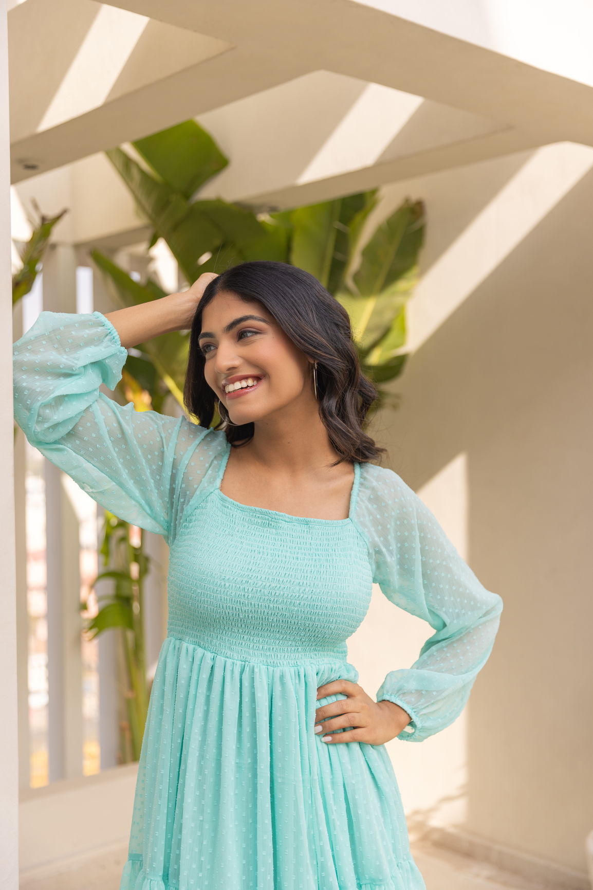 Smiling woman in mint green chiffon maxi dress with puff sleeves.
