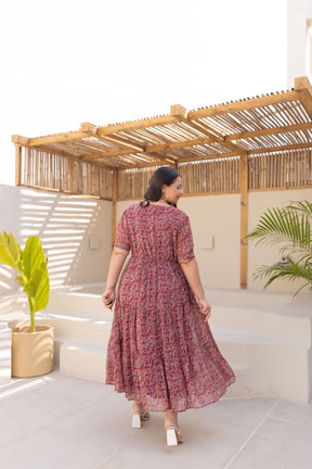 Plus-size woman in floral MOTIF MAXI POLAGO PLUS dress, showcasing back view.