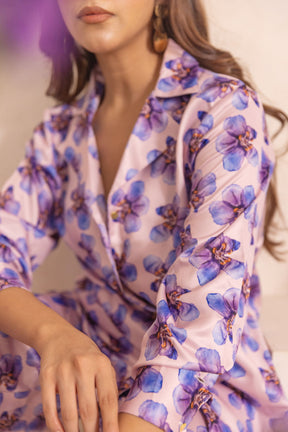 Woman wearing pastel satin co-ord with floral print design.