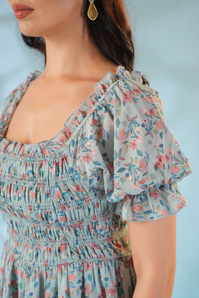 Pastel smocked nursing maxi dress with floral design and puff sleeves.