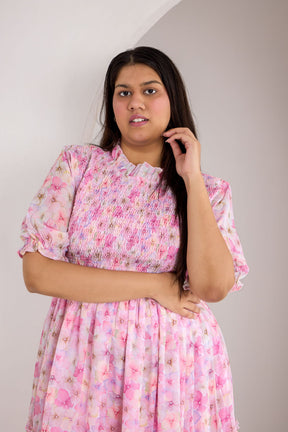 Pastel smocked maxi dress in pink floral pattern for women.