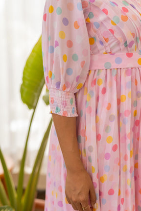 Pink polka dotted pleated maxi dress with puff sleeves.