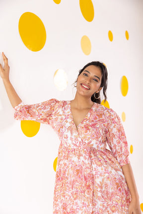 Woman wearing pleated motif maxi dress against a colorful backdrop.