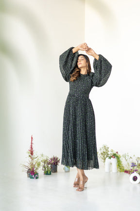 Elegant model in floral pleated maxi dress with puff sleeves.