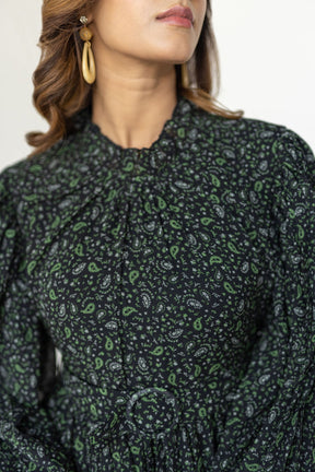 Elegant woman wearing PLEATS ON PLEATS MAXI dress with floral pattern.