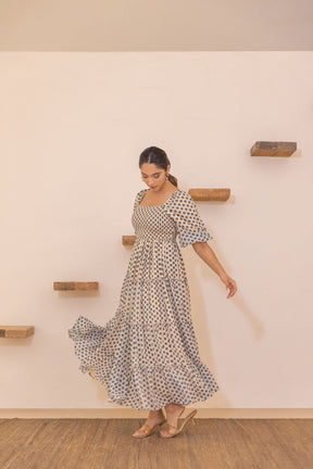 Polka smocked maxi dress flowing elegantly on model.