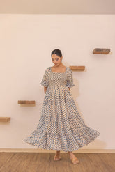 Polka smocked maxi dress with flutter sleeves and layered skirt.