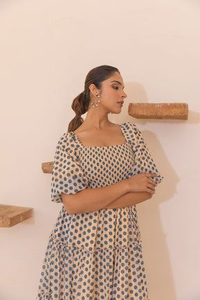 Polka smocked maxi dress styled elegantly against a minimalist backdrop.