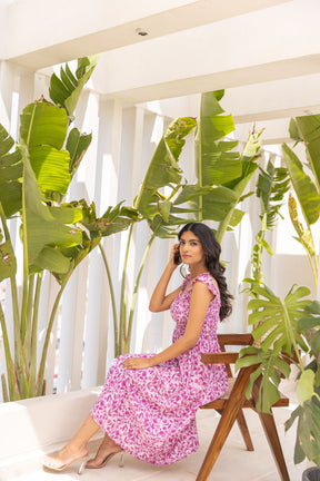 Stylish woman wearing Pretty in Pink Maxi Dress surrounded by greenery.