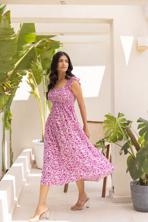 Model in Pretty in Pink Maxi Dress surrounded by greenery.