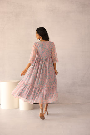 Woman wearing a grey and pink floral maxi dress, stylish and elegant.
