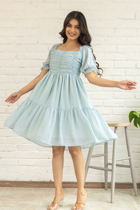 Pastel green midi dress with puff sleeves, stylish and playful look.