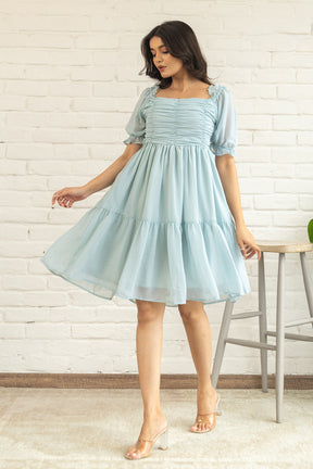 Pastel green midi dress with puff sleeves and flowy skirt.