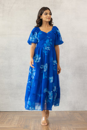 Model in a royal blue floral maxi dress with puff sleeves.