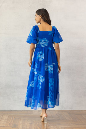 Royal blue maxi dress with floral design and puff sleeves.