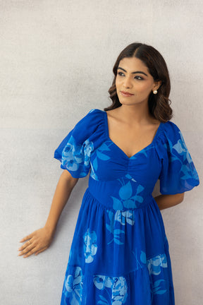 Stylish woman in royal blue floral maxi dress, perfect for summer.