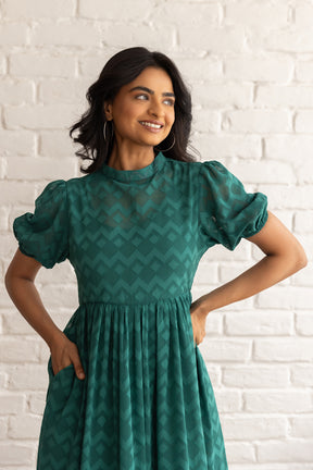 Elegant green maxi dress with textured pattern and puff sleeves.