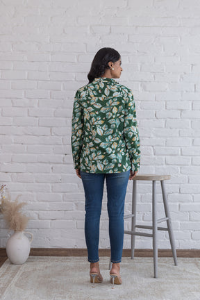 Back view of a woman in a green cotton shirt top.
